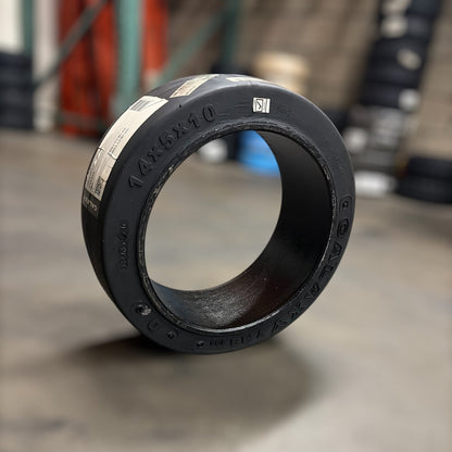 14x5x10smooth black rubber forklift tire  engraved text on a concrete floor