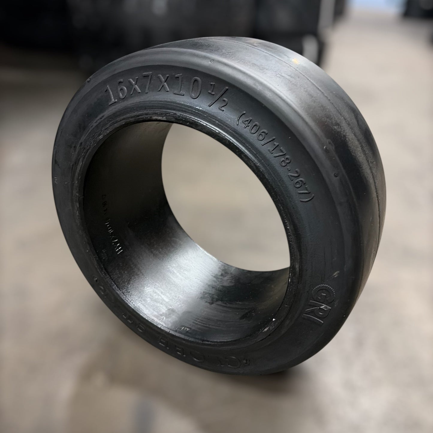 16x7x10.5 forklift tire with blurred warehouse background
