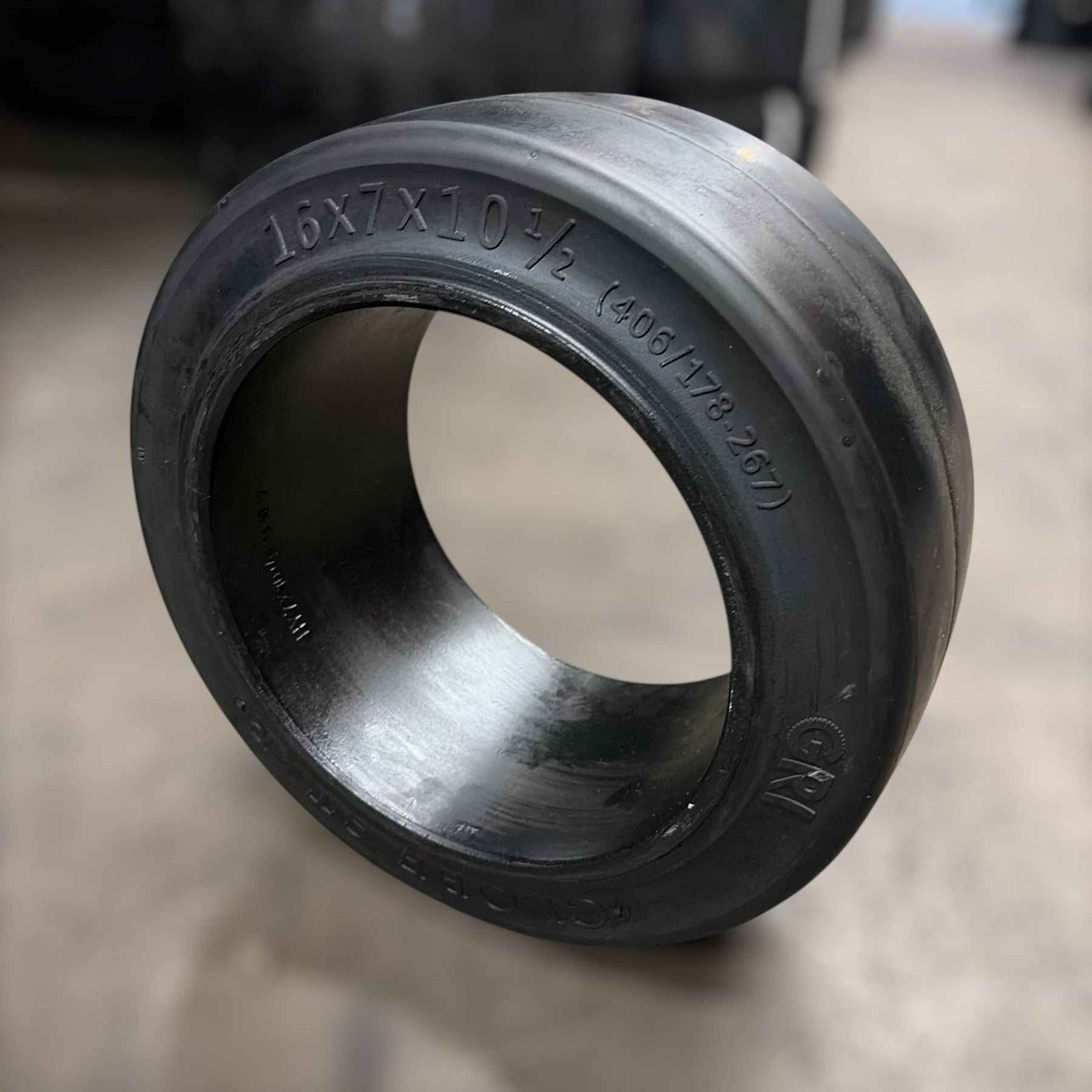 16x7x10.5 forklift tire with blurred warehouse background