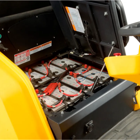 Close-up of batteries inside a yellow vehicle with visible labels. cat c70r sweeper